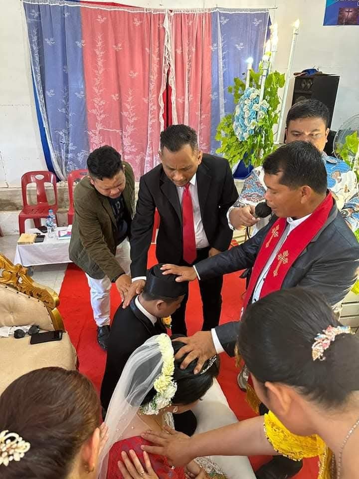 Gembala sidang mendoakan pasangan pengantin pada pemberkatan pernikahan