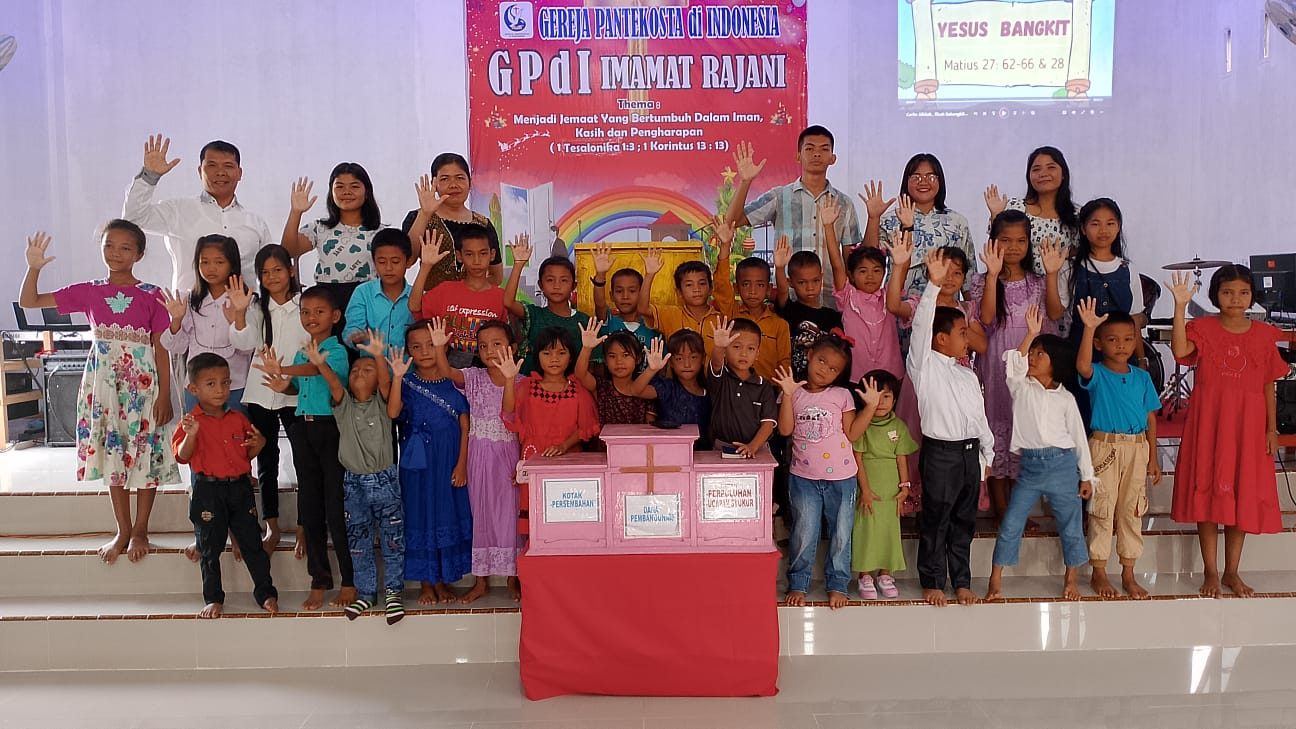 Anak-anak Sekolah Minggu GPdI Imamat Rajani bersama guru mengangkat tangan