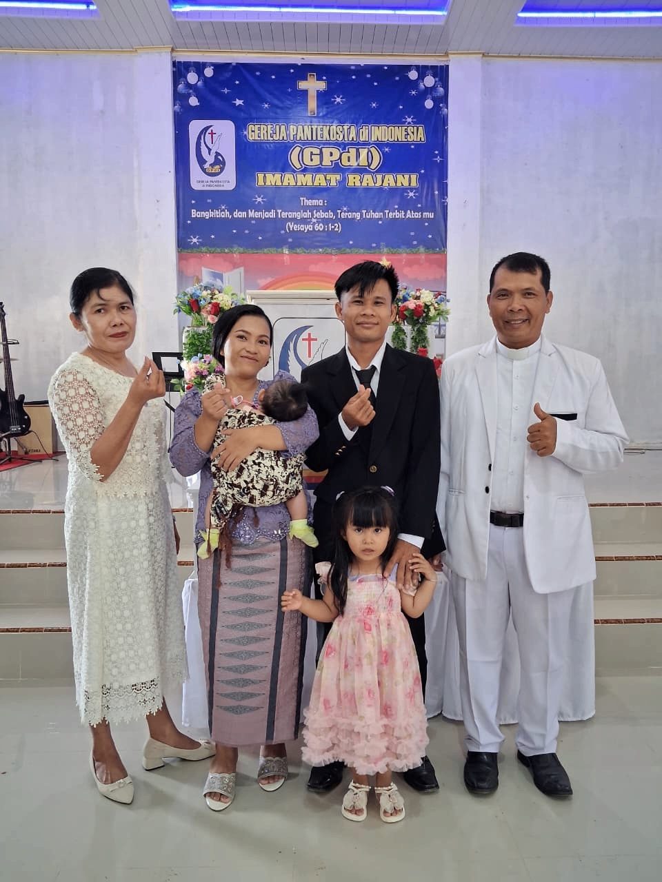 Keluarga menyerahkan bayi mereka bersama Gembala Sidang dan istri