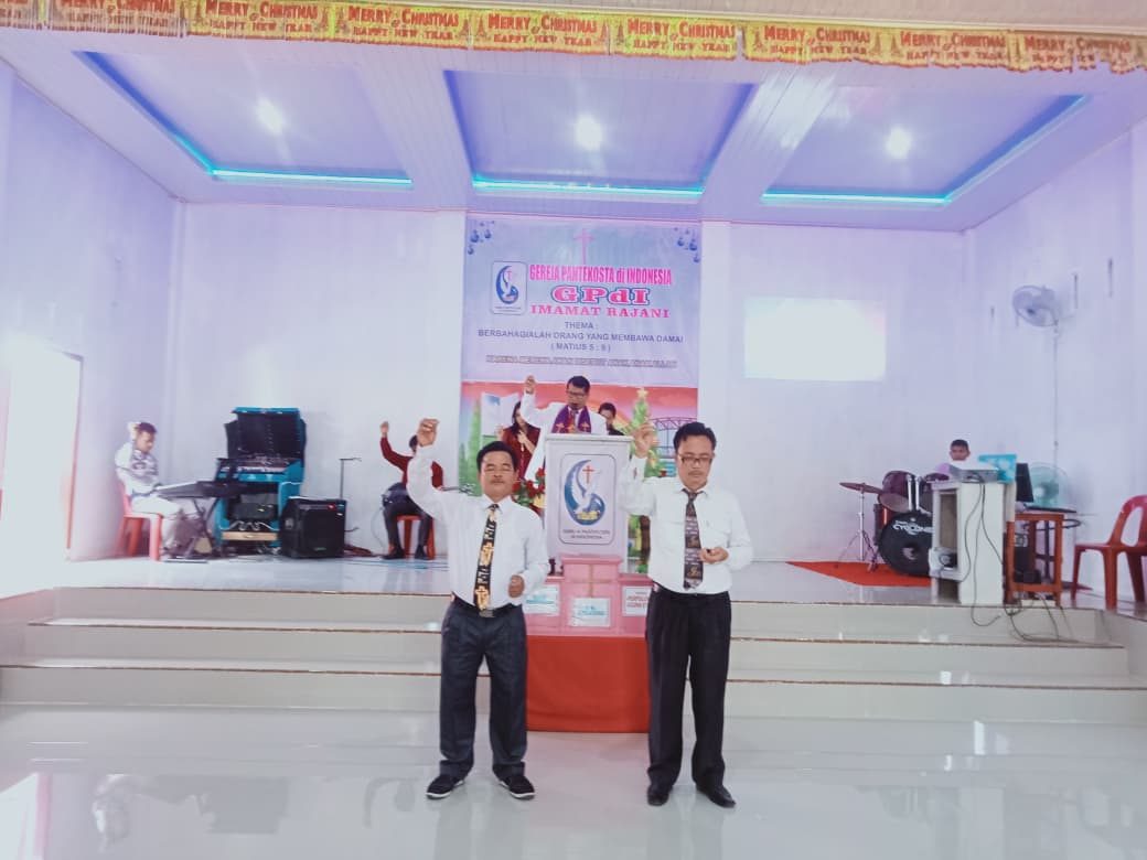 Dua pelayan memimpin pujian pada ibadah Natal di gedung gereja