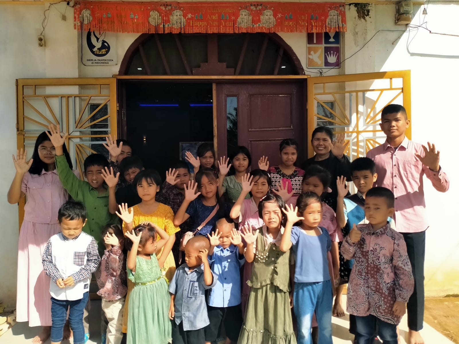 Anak-anak Sekolah Minggu berfoto bersama di depan pintu gereja