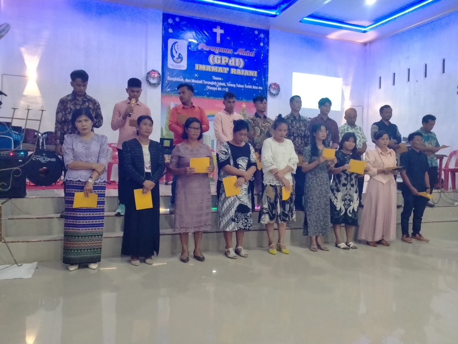 Pelayan dan jemaat menerima kartu ucapan pada ibadah Natal